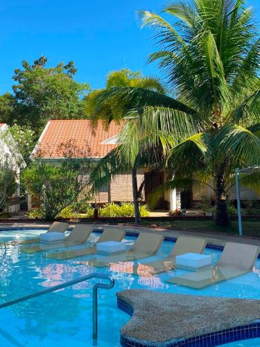 a swimming pool with lounge chairs and palm trees at Sunville Hotel and Restaurant in Panglao Island