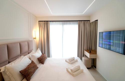 a bedroom with a white bed with a large window at The Grand Blue Boutique Hotel in Missolonghi