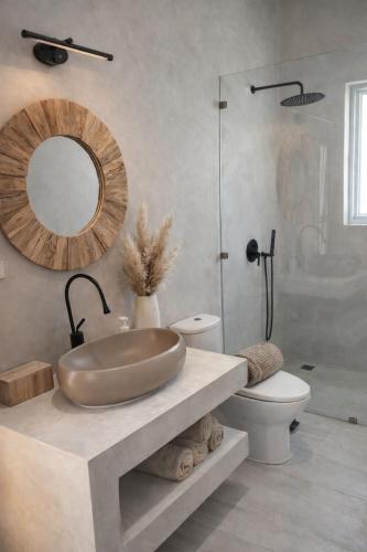 a bathroom with a sink and a toilet and a mirror at Jungle Home in Koh Samui