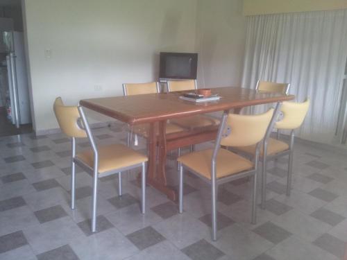 una mesa de madera y sillas en una habitación en Casa soñada con vista a la Sierra de los Comechingones en Merlo