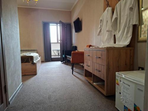 a room with a bed and a dresser with a mirror at Hotel Mardin in Almaty