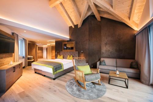 a bedroom with a bed and a couch at Premium Activehotel Bergkönig in Neustift im Stubaital