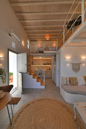 a room with a bed and a staircase in a house at Molos Tinos Cycladic house in Panormos