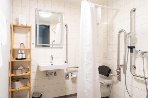 a bathroom with a sink and a toilet and a shower at Gästehaus Hunziker in Zurich