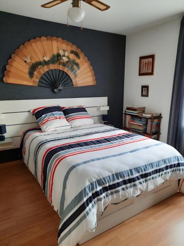 a bedroom with a large bed with a wooden headboard at Chambres Du Bois Des Hâtes in Saint-Avertin