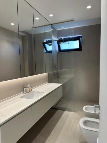 a bathroom with a sink and a toilet and a mirror at Azure Pool Villa in Lalzit Bay