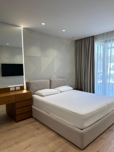 a bedroom with a large bed and a television at Azure Pool Villa in Lalzit Bay