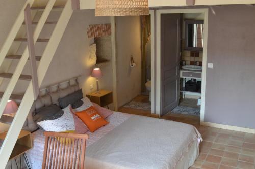 a bedroom with a bed and a staircase in it at Tamaris in La Jarrie