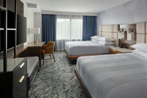 a hotel room with two beds and a desk at Marriott Raleigh Durham Research Triangle Park in Durham