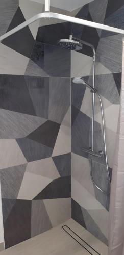 a shower with a glass door in a bathroom at Trémière et cabane in La Jarrie