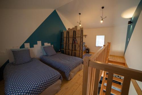 a bedroom with two beds and a stair case at Trémière et cabane in La Jarrie