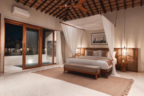 a bedroom with a bed with a canopy at Salty Lotus in Uluwatu