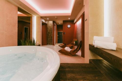 a large bathroom with a tub and a hammock at Hotel ARA - Dancing Club Restauracja Kameralne SPA ARA in Jastrzębia Góra