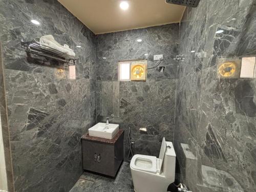 a bathroom with a toilet and a sink at S K Tower Hotels in Nawāda