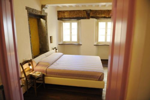 コルトーナにあるLocanda pane e vinoのベッドルーム1室(ベッド1台、窓2つ付)