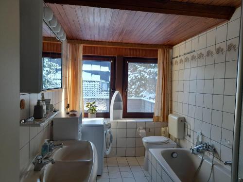 a bathroom with a sink and a toilet and a tub at Eichhörnchen, Ferienwohnung in Schneverdingen