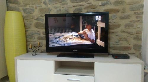a flat screen tv sitting on top of a white dresser at Le Vecchie Mura Apartment in Cannara