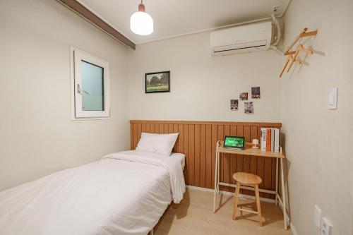 a bedroom with two beds and a desk with a computer at Wayhome Gasan in Seoul