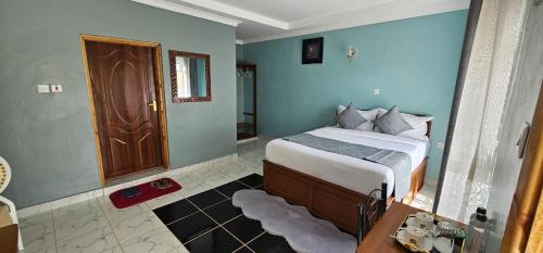 a bedroom with a bed and a wooden door at Juniper Park Resort in Nyahururu