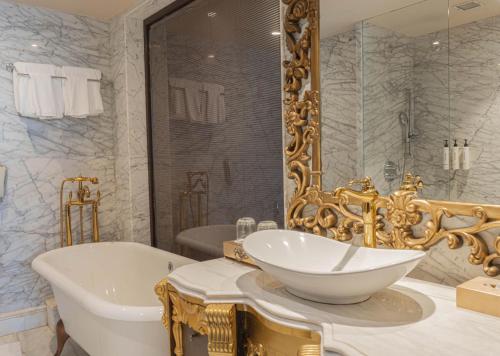 a bathroom with a tub and a large mirror at Seven Seas Hotel in New Delhi