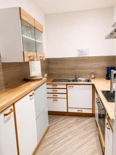 a kitchen with white cabinets and a sink at Pension Pohl in Wenden