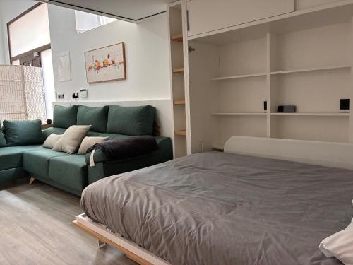 a bedroom with a green bed and a couch at Villa Abril en el Porvenir in Seville