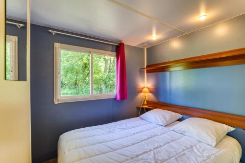 a bedroom with a bed and a window at Mon Gite En Camargue in Le Cailar