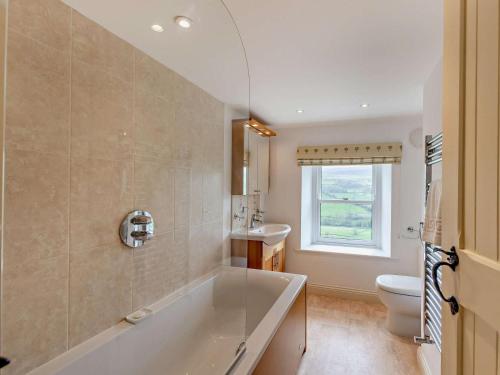 a bathroom with a tub and a toilet and a sink at 4 Bed in Richmond oc-g0083 in Feetham