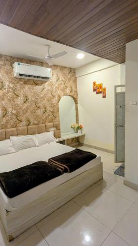 a bedroom with a bed and a stone wall at KSHIPRA GUEST HOUSE in Ujjain