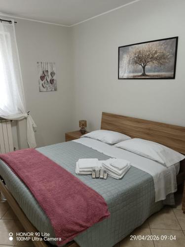a bedroom with a bed with towels on it at Serena House in Robella