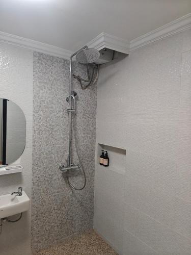 a shower stall in a bathroom with a sink at Moya Villa & Resto in Cihideung