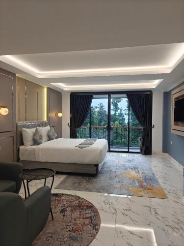 a bedroom with a bed and a large window at Moya Villa & Resto in Cihideung