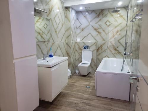 a bathroom with a toilet and a sink and a shower at Panoramic Sea View Apartment Saranda in Sarandë