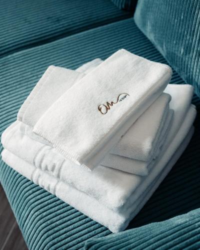 a pile of white towels sitting on a bed at OM Resort in Gura Teghii
