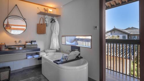 a bathroom with a toilet and a sink and a balcony at PURE Hotel Lijiang in Lijiang