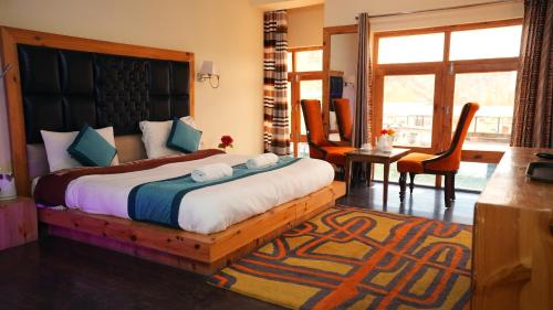 a bedroom with a large bed with a wooden frame at Hotel DE Suzain-Leh in Leh