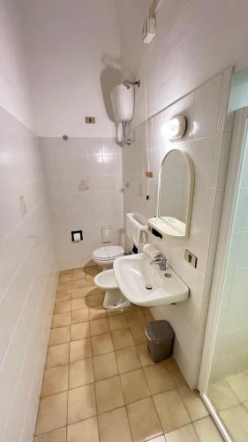 a bathroom with two toilets and a sink and a mirror at Albergo Pensione Bartoli in Castiglioncello