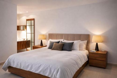 a bedroom with a large white bed with two lamps at Seafront-Top Location-Close To Shops & Restaurants in St. Julianʼs