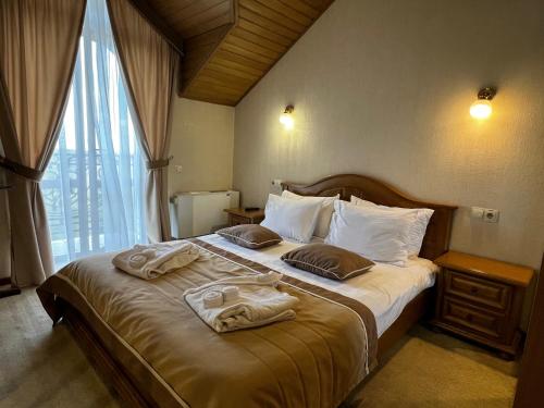 a bedroom with a large bed with towels on it at Курортний Готель Золота Корона in Truskavets