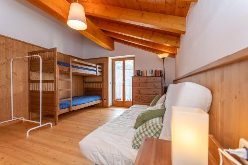a bedroom with a bunk bed and wooden walls at El Feral - Mansarda in Selva di Cadore