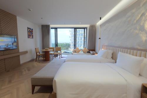 a hotel room with two beds and a television at Mona Luxe Apartment Hoi An in Hà My Tây (2)