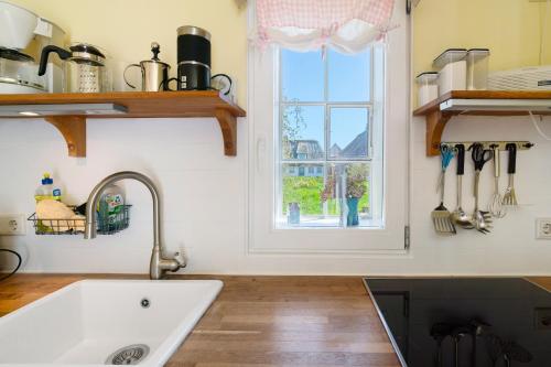 a kitchen with a sink and a window at Haus Bei Der Kirche in Oland