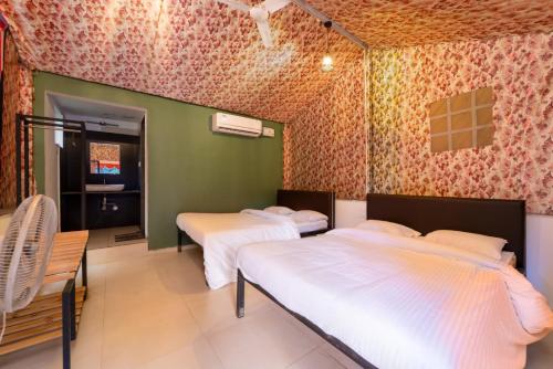 a room with three beds and a tv in it at Dandeli Kali Resort in Dandeli