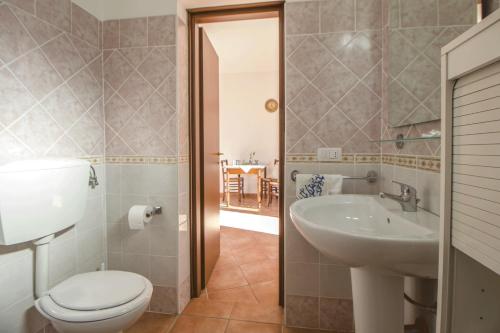 y baño con aseo y lavamanos. en Casa Vacanze Cau - Viale Europa, en Alghero