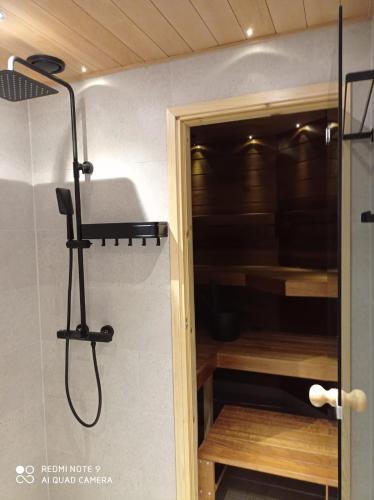a shower in a room with a glass door at Alppitalo 3 as 3 in Tahkovuori
