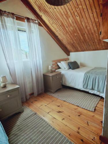 a bedroom with a bed and a wooden ceiling at Mienru House Self Catering Cottage in Riviersonderend