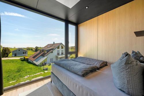 a bedroom with a large window and a bed at Chalet Seewald - Tiny House in Seewald