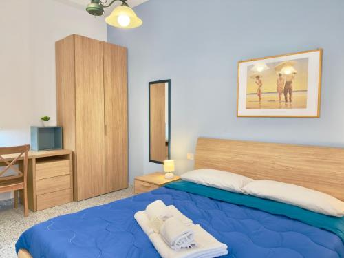 a bedroom with a blue bed and a wooden cabinet at VICO 11 Gaeta - UN LETTO IDEALE in Gaeta