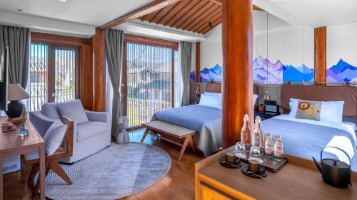 a bedroom with two beds and a couch and a table at PURE Hotel Lijiang in Lijiang