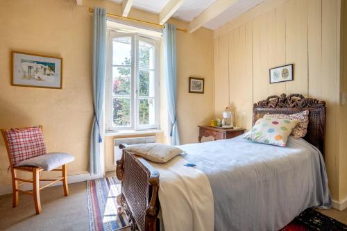 a bedroom with a bed and a window and a chair at Kervégant Chambres D'hôtes in Riec-sur-Bélon